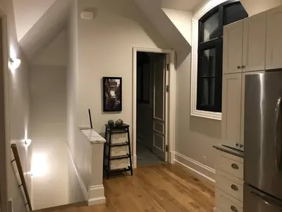 a kitchen with a staircase leading up to a door at Chateau Calcaire Carriage House in Kelowna