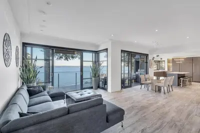 a living room with a couch and a dining room at The Sunset Lane Waterfront Home in West Vancouver