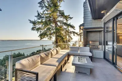 a patio with a couch and a view of the water at The Sunset Lane Waterfront Home in West Vancouver