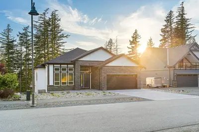 a house with a garage in a driveway at Stylish Retreat in Agassiz with Scenic Views in Agassiz