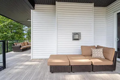 acovered porch with a couch on a house at Stylish Retreat in Agassiz with Scenic Views in Agassiz