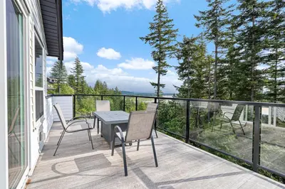 a patio with a table and chairs on a balcony at Stylish Retreat in Agassiz with Scenic Views in Agassiz