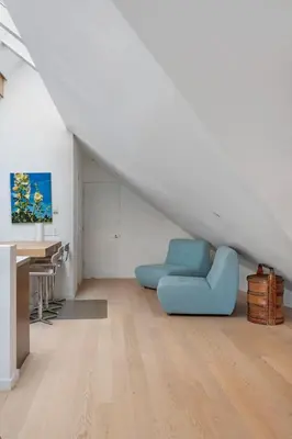 a living room with a blue chair and a desk at Beautiful, Newly Renovated Creek Home in Vancouver