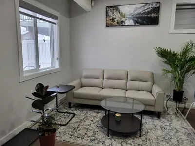 a living room with a couch and two tables at Cozy and Modern Suite - Your Home Away from Home! in Calgary
