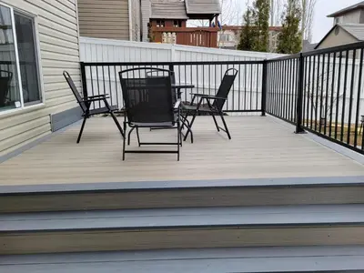 a porch with three chairs and a table on it at Cozy and Modern Suite - Your Home Away from Home! in Calgary