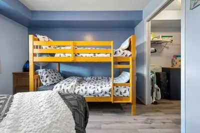 a bedroom with two bunk beds and a blue wall at The Beach House Pool Access 5 Min Walk to Lake Sleeps 8 in Invermere