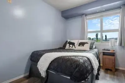 a bedroom with a bed and a window at The Beach House Pool Access 5 Min Walk to Lake Sleeps 8 in Invermere