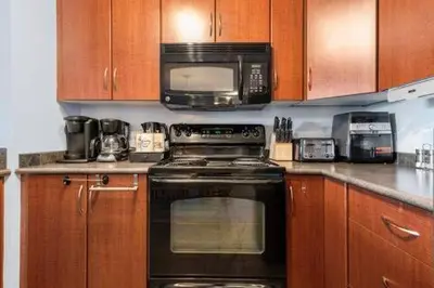 a kitchen with a black stove and a microwave at The Beach House Pool Access 5 Min Walk to Lake Sleeps 8 in Invermere
