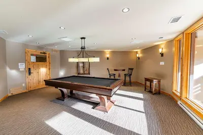 a room with a pool table and a dining room at Stunning 2bd hot tub walking distance to downtown in Canmore