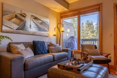 a living room with a couch and a table at Stunning 2bd hot tub walking distance to downtown in Canmore