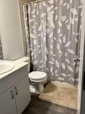 a bathroom with a toilet and a shower curtain at Bedroom in Southwest D in Edmonton