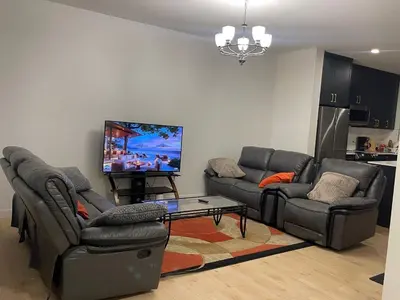 a living room with couches and a flat screen tv at Bedroom in Upland A in Edmonton