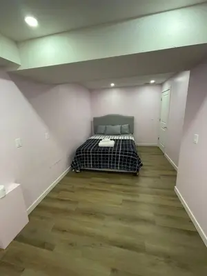 a bedroom with a bed in the middle of a room at Bedroom in Upland C in Edmonton