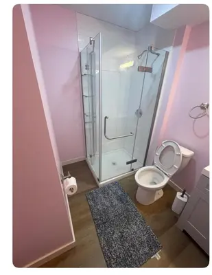 a bathroom with a toilet and a glass shower at Bedroom in Upland C in Edmonton
