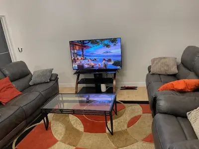 a living room with two couches and a flat screen tv at Bedroom in Upland C in Edmonton