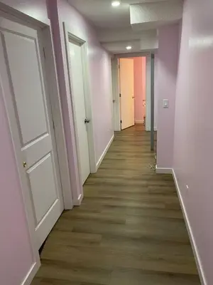 an empty hallway with pink walls and wooden floors at Bedroom in Upland C in Edmonton