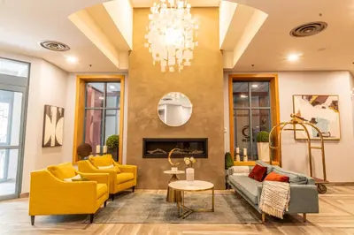 a living room with yellow furniture and a chandelier at Alpenglow Lodge by Elevate Vacations in Whistler