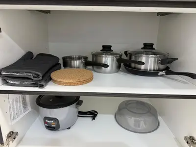 a shelf with pots and pans in a kitchen at THE GUEST HOUSE WEST EDMONTON Mall in Edmonton