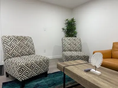 a living room with two chairs and a coffee table at THE GUEST HOUSE WEST EDMONTON Mall in Edmonton