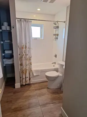 a bathroom with a toilet and a tub and a shower at Happy Zone Suite - Sleeps 4, Free Treats ! in Langford