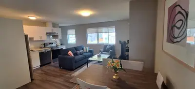 a living room with a blue couch and a table at Happy Zone Suite - Sleeps 4, Free Treats ! in Langford