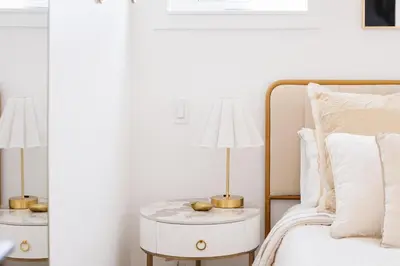 a bedroom with a bed and a lamp on a side table at Brass Apple Cottage in Campbell River