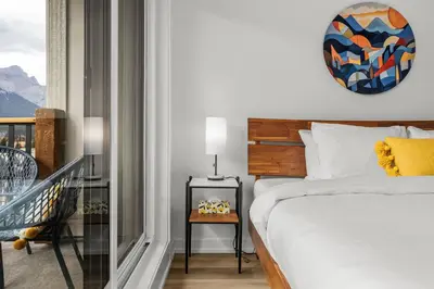 a bedroom with a bed and a balcony at Golden Escape 2 Bdrm Mountain VIEWS - managed by Little Sister Getaways in Canmore