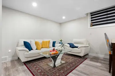 a living room with two couches and a glass table at Modern 2BR Private Suite NW Near Airport & Amazing Shopping! Free Banff Pass, Netflix, Parking! in Calgary