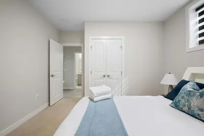 a bedroom with a white bed and a blue rug at Modern 2BR Private Suite NW Near Airport & Amazing Shopping! Free Banff Pass, Netflix, Parking! in Calgary