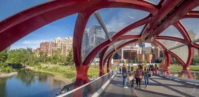 a group of people walking on a bridge over a river at Modern 2BR Private Suite NW Near Airport & Amazing Shopping! Free Banff Pass, Netflix, Parking! in Calgary