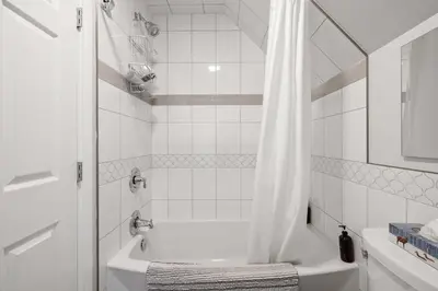 a white bathroom with a tub and a shower at Local Loft - Downtown Okotoks - 2BD - Private in Okotoks