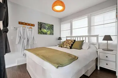 a white bedroom with a bed and a dresser at Local Loft - Downtown Okotoks - 2BD - Private in Okotoks