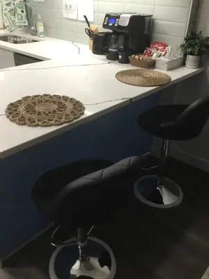 a counter with two black stools in a kitchen at Almost Heaven - Cozy 2BDRM APT near Heritage Park,Spruce Meadows & Banff-SW Calgary in Calgary