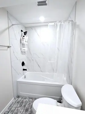 a white bathroom with a tub and a toilet at A Cozy Home away from Home in Edmonton