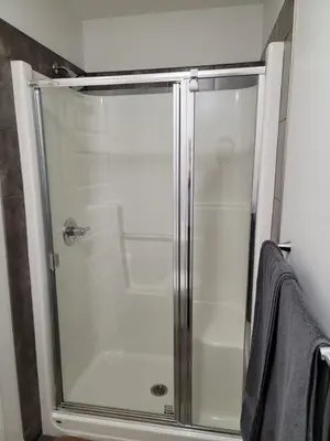 a shower with a glass door in a bathroom at Exquisite Entire 4- Bed rooms vacation home! in Calgary