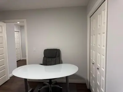 a white table and a chair in a room at Exquisite Entire 4- Bed rooms vacation home! in Calgary