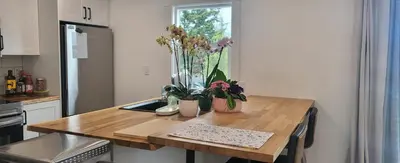 a kitchen with a wooden table with flowers on it at Sea view stay in Lantzville