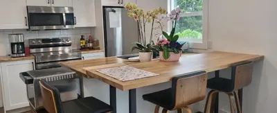 a kitchen with a wooden table and two chairs at Sea view stay in Lantzville