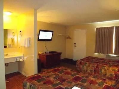 a hotel room with two beds and a flat screen tv at Canadas Best Value Inn Whitecourt in Whitecourt