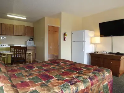 a hotel room with a bed and a kitchen at Canadas Best Value Inn Whitecourt in Whitecourt