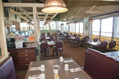 a dining room with tables and chairs in a restaurant at Canadas Best Value Inn Whitecourt in Whitecourt