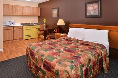 a hotel room with a bed and a kitchen at Canadas Best Value Inn Whitecourt in Whitecourt