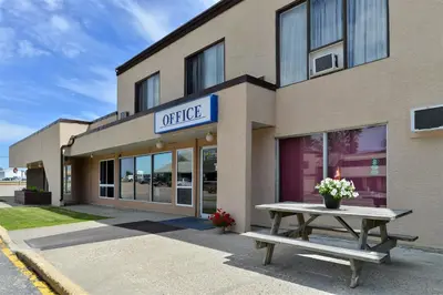 a building with a picnic table in front of it at Canadas Best Value Inn Whitecourt in Whitecourt