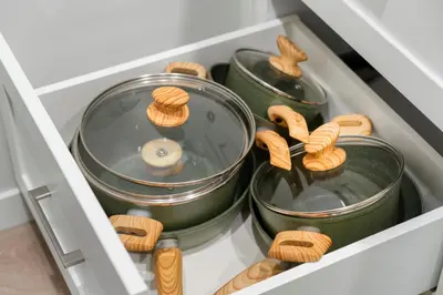 a drawer full of pots and pans with wooden handles at Tropical Caribbean-Themed Cozy Getaway - King Bed-Free Parking in Calgary