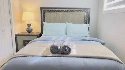 a bed with two pairs of slippers on it at Calgary Airport Stay Private Suite 1Bed in Calgary