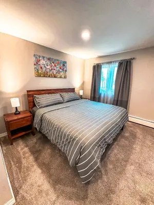 a bedroom with a large bed and a window at Modern Downtown Stay in Yellowknife