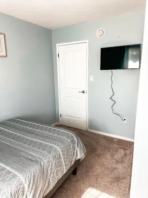 a bedroom with a bed and a flat screen tv at Modern Downtown Stay in Yellowknife