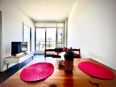 two pink umbrellas on a wooden table in a living room at Fashion 1B1B locates in the heart of Richmond in Richmond