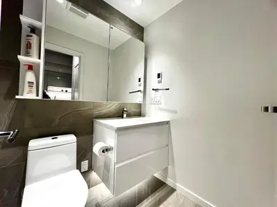 a bathroom with a toilet and a sink and a mirror at Fashion 1B1B locates in the heart of Richmond in Richmond