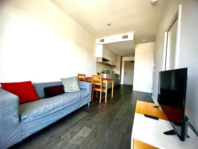 a living room with a blue couch and a kitchen at Stylish 1B1B locates in the heart of Richmond in Richmond